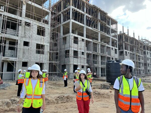 Students outside building project. Photo.